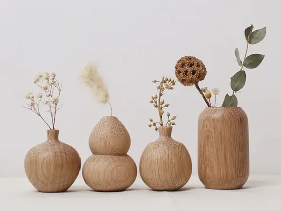 What influence does the material of a vase have on flower arrangement?